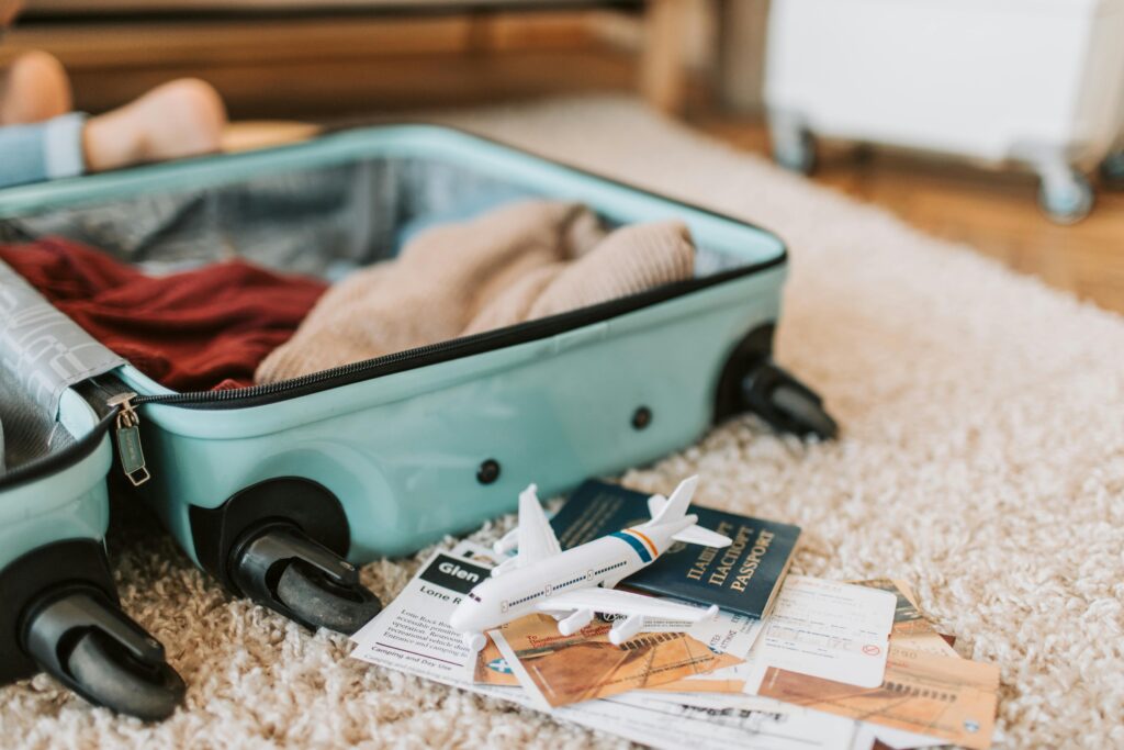 Black and Green Luggage Bag with international passport on Brown Carpet